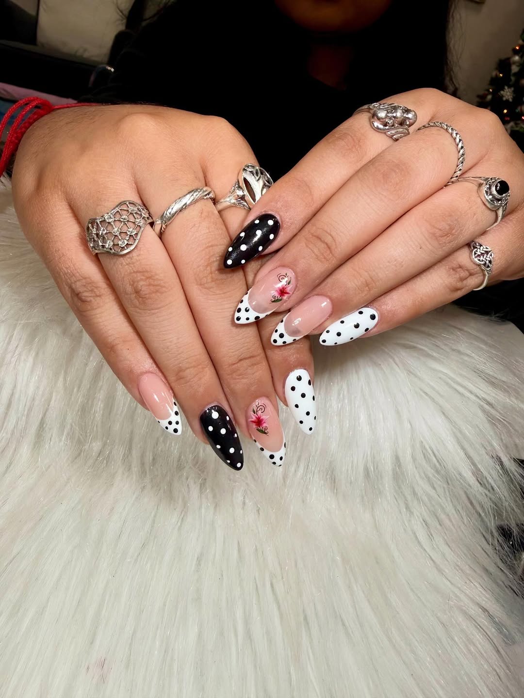 Black and white polka dot nail art with pink flowers